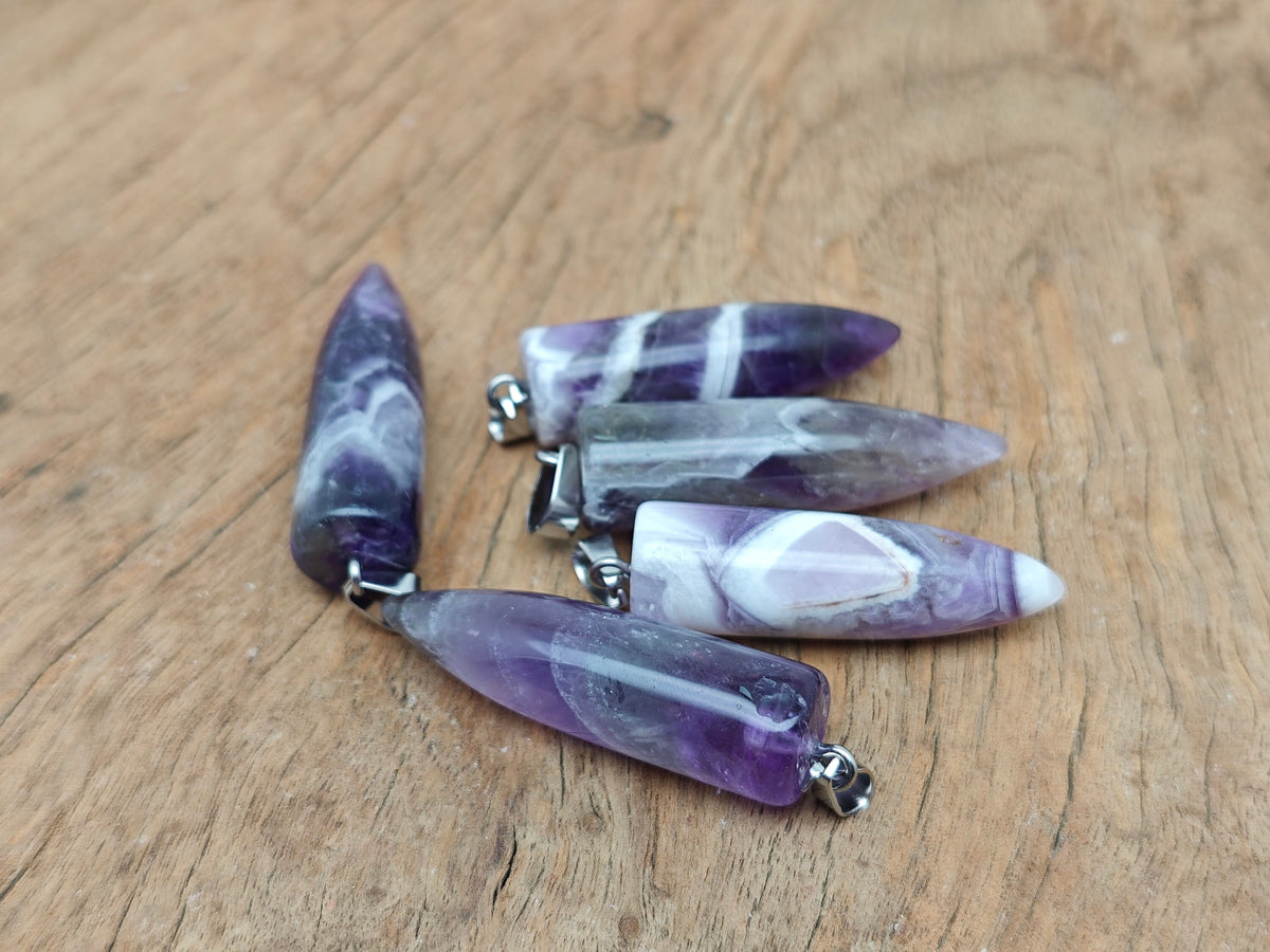 Polished Amethyst Bullet gemstone pendant with carved details, featuring a natural purple amethyst stone on a jewelry chain.