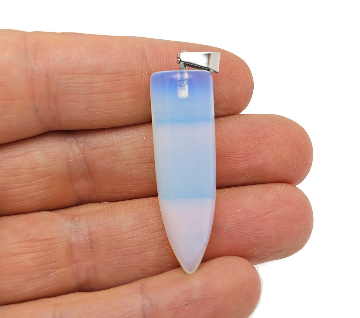 Polished opalite bullet gemstone pendant with carved details, showcasing a smooth, translucent gemstone on a simple cord.