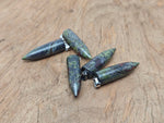 Polished Dragon Blood Jasper bullet gemstone pendant with carved details, showcasing rich red and brown tones, by GemstoneGO.