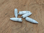 Polished Howlite bullet gemstone pendant with carved details, featuring a smooth, polished finish and natural white and gray colors.