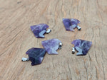 Amethyst gemstone wolf head pendant with detailed carvings, hanging from a silver chain, showcasing crystal jewelry craftsmanship.