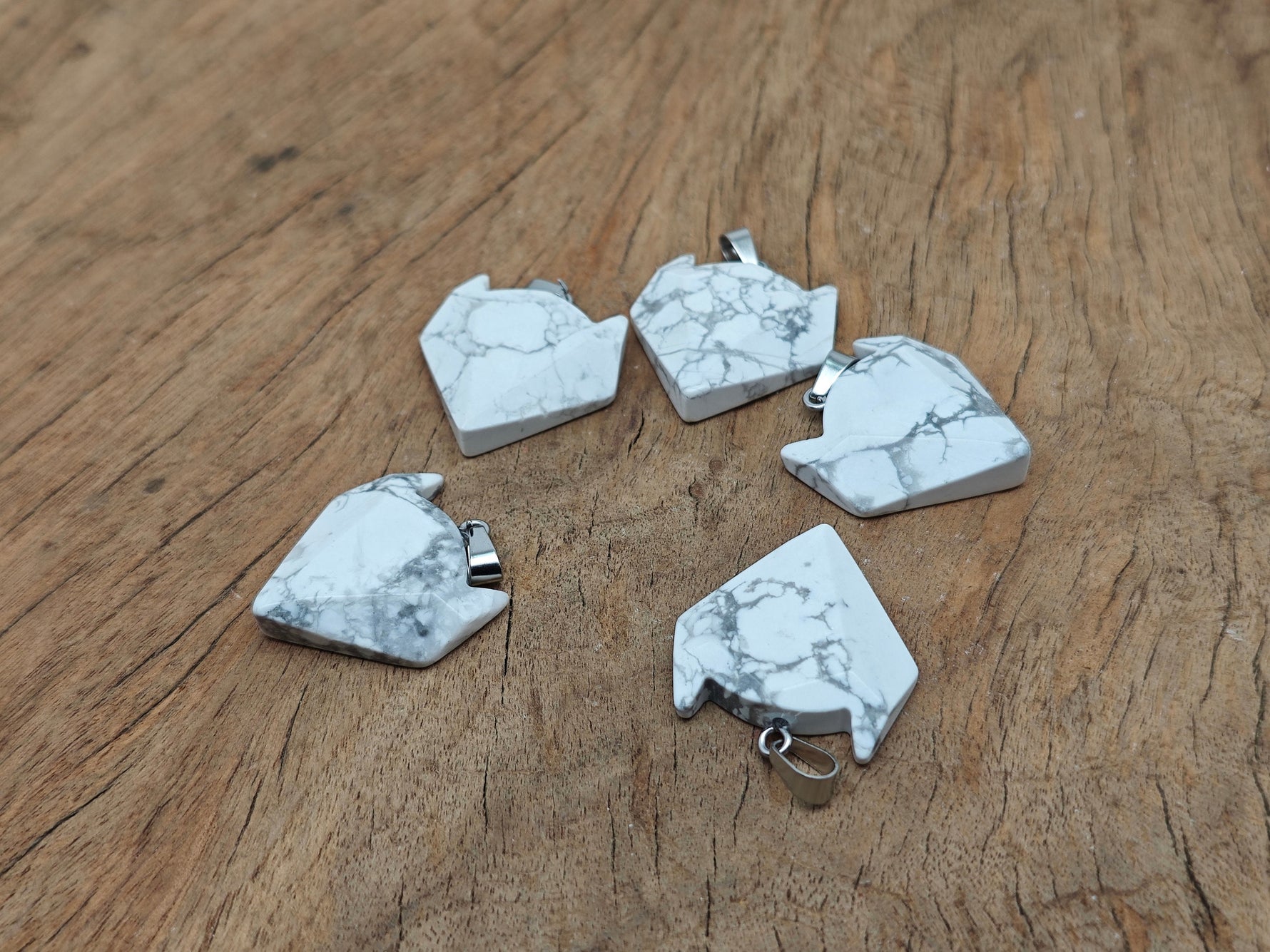 Howlite wolf head gemstone pendant from GemstoneGO featuring a carved crystal wolf design on a polished pendant.