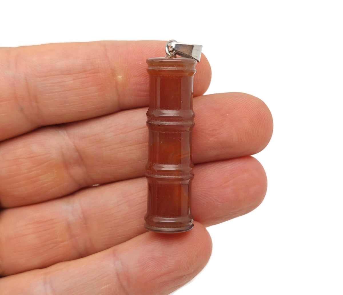 Carnelian bamboo-shaped crystal pendant with protective energy, featuring a vibrant orange carnelian stone on a silver chain.