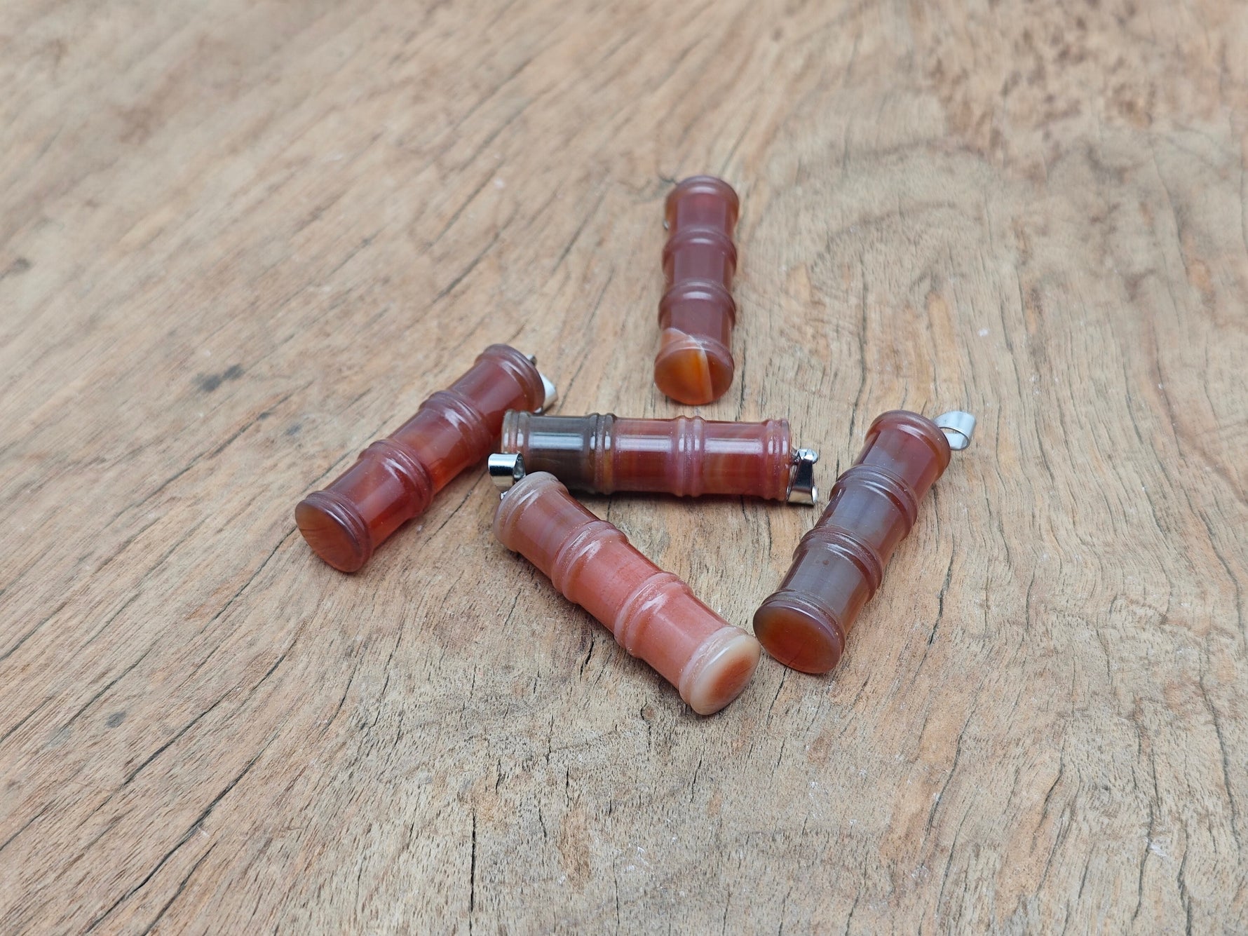 Carnelian bamboo-shaped crystal pendant from GemstoneGO featuring a protective crystal design on a silver chain.