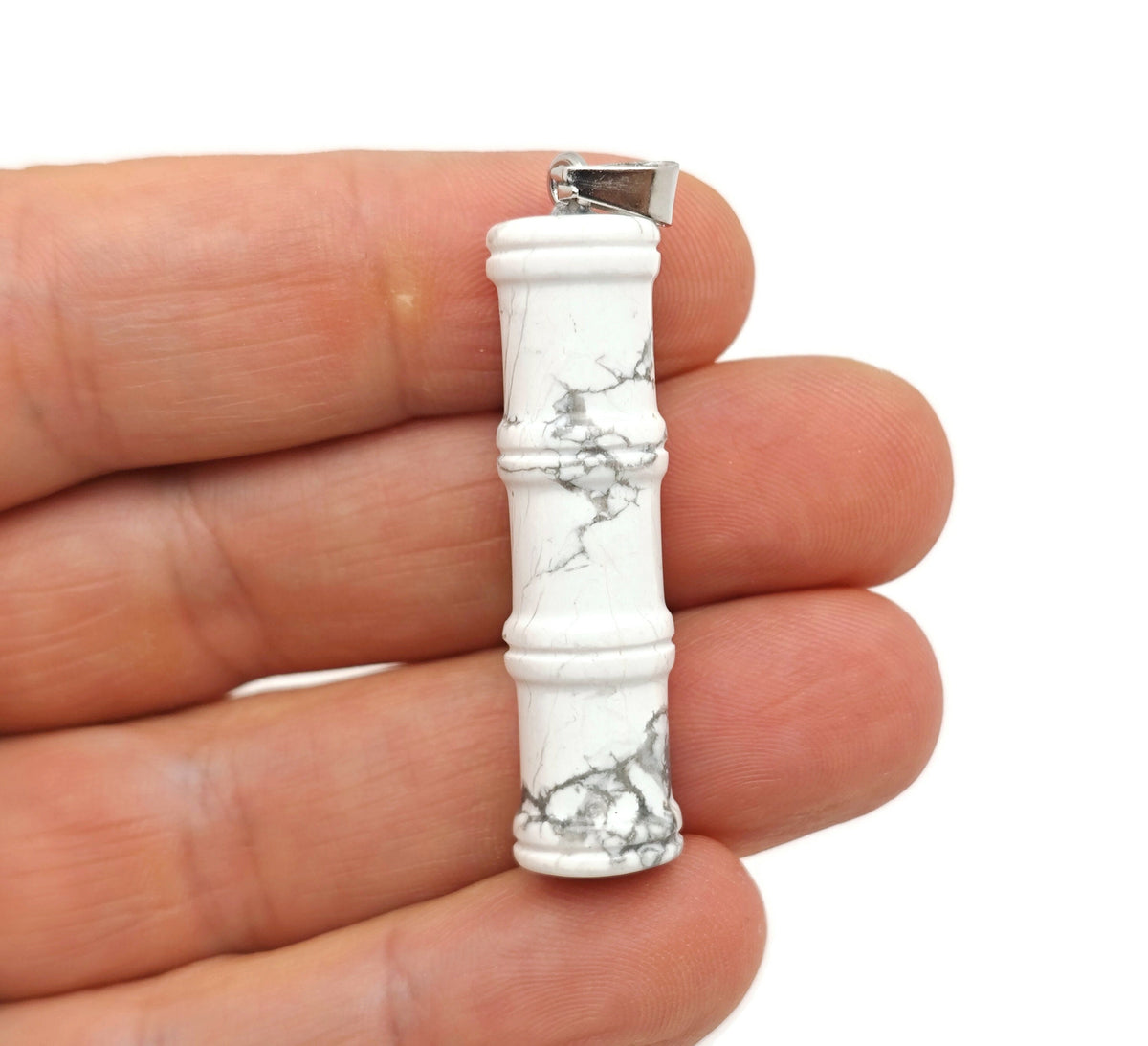 Close-up of a Howlite crystal pendant in bamboo shape, featuring protective crystal properties, from GemstoneGO.