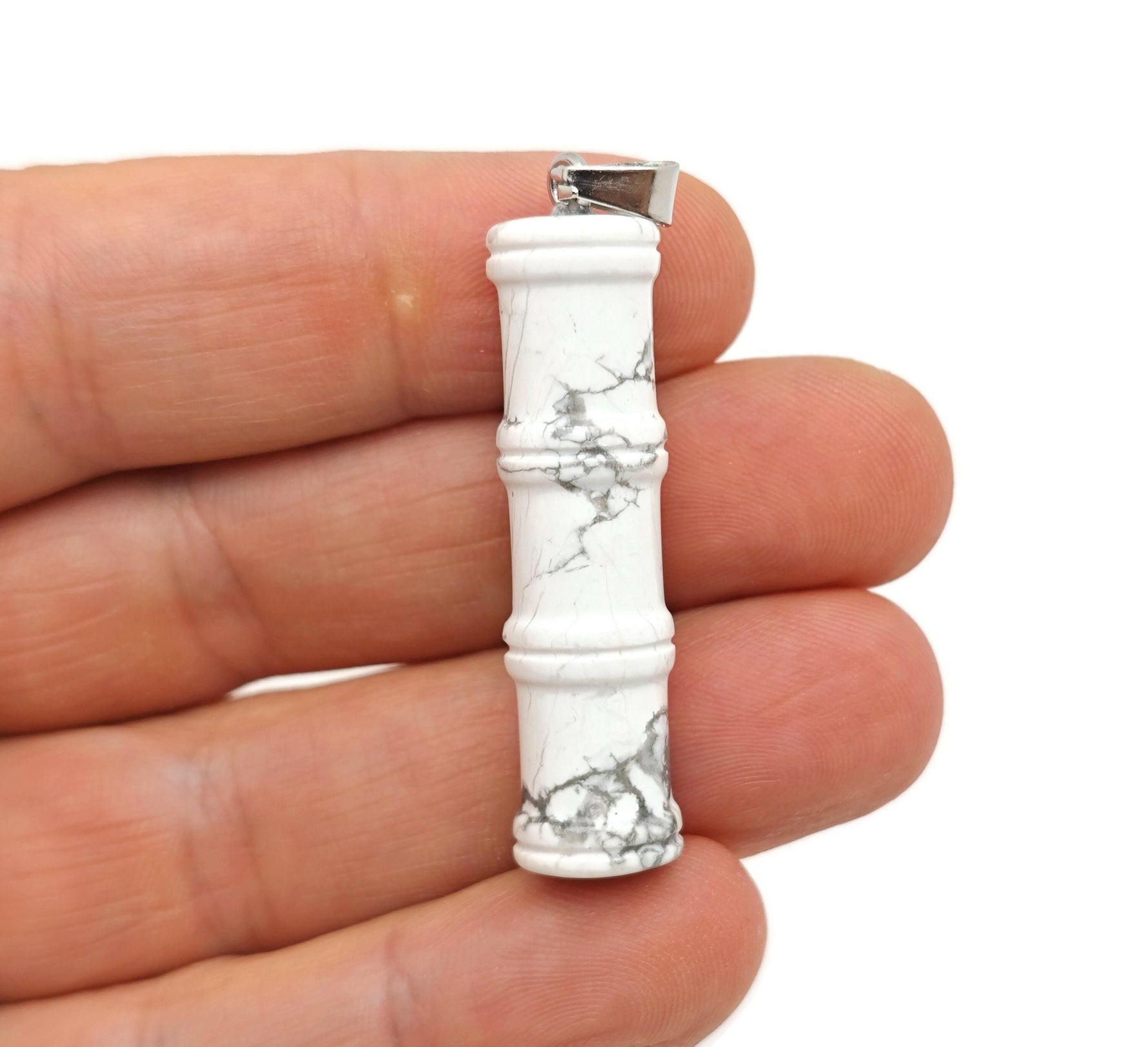 Close-up of a Howlite crystal pendant in bamboo shape, featuring protective crystal properties, from GemstoneGO.