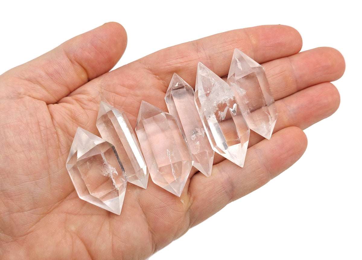 Clear quartz double terminated point wand from GemstoneGO displayed on a neutral background, showcasing its transparent crystalline structure.