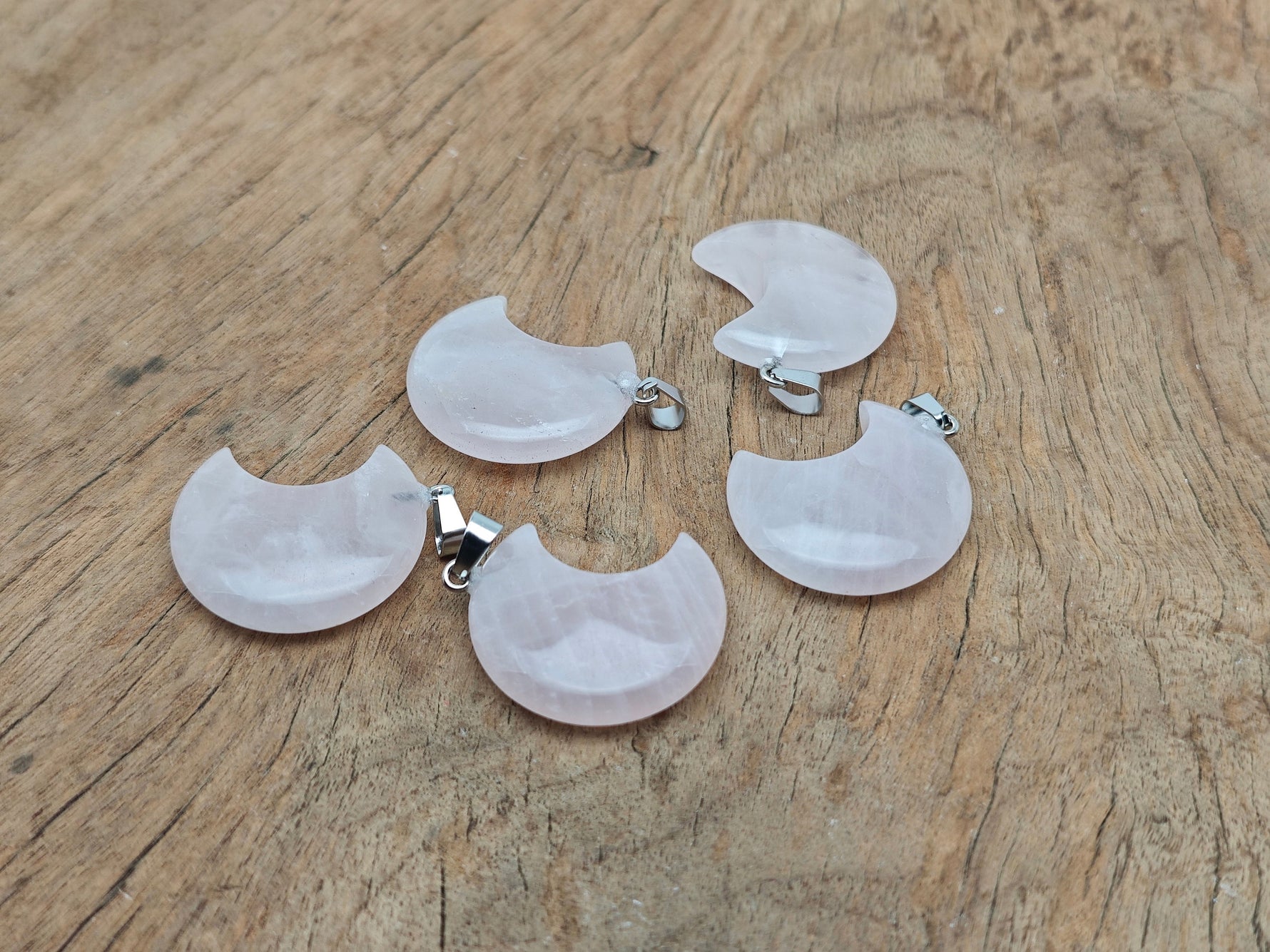 Rose quartz moon pendant with crescent shape from GemstoneGO, showcasing a smooth, polished gemstone on a delicate chain.