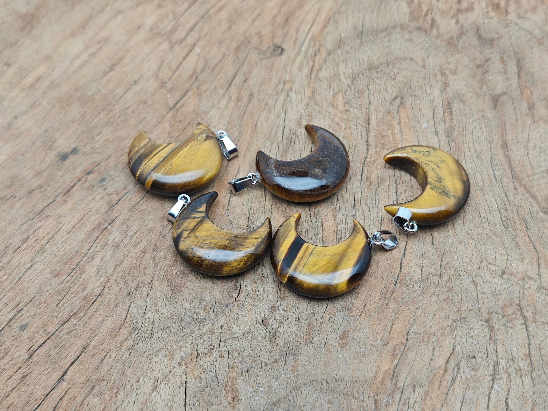Tiger Eye moon pendant featuring a crescent moon design from GemstoneGO, showcasing the polished gemstone with a silver bail.