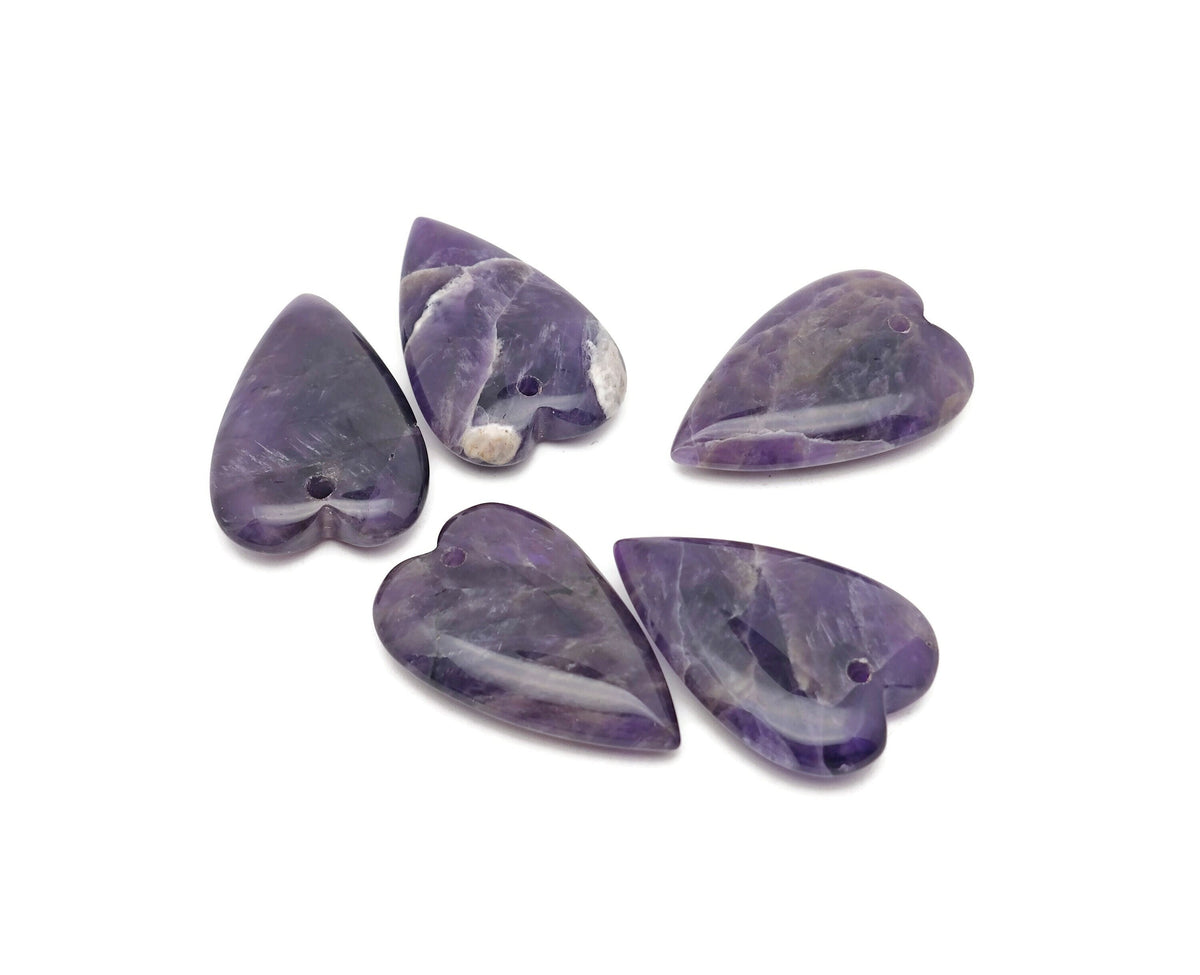 Heart-shaped amethyst love crystal pendant with a polished gemstone, showcasing a vibrant purple hue and intricate carving.