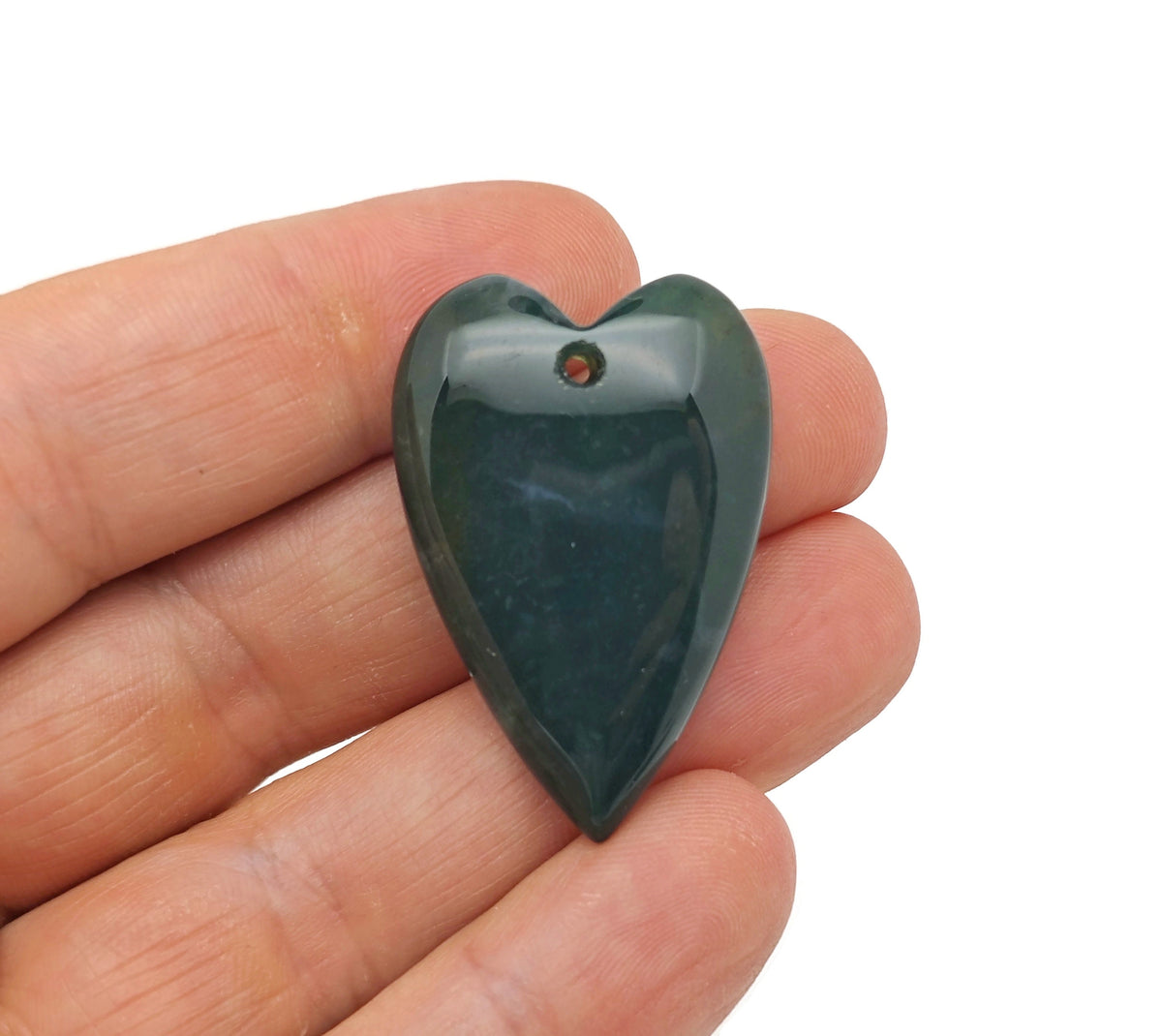 Heart-shaped moss agate pendant with a polished, natural gemstone displaying green and brown patterns, hanging from a silver chain.
