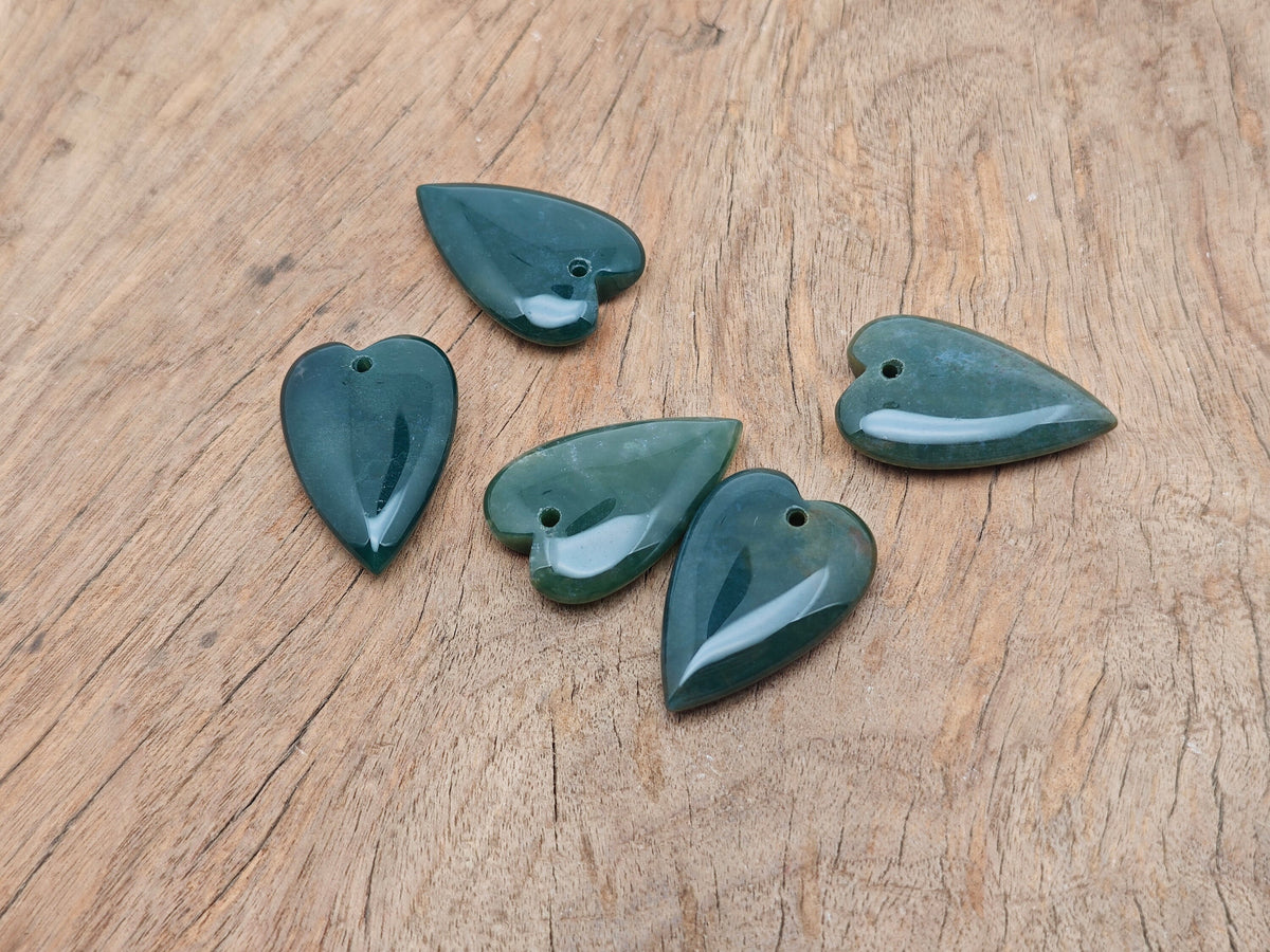 Heart-shaped moss agate pendant featuring a healing gemstone with natural green and brown patterns, hanging from a delicate chain.
