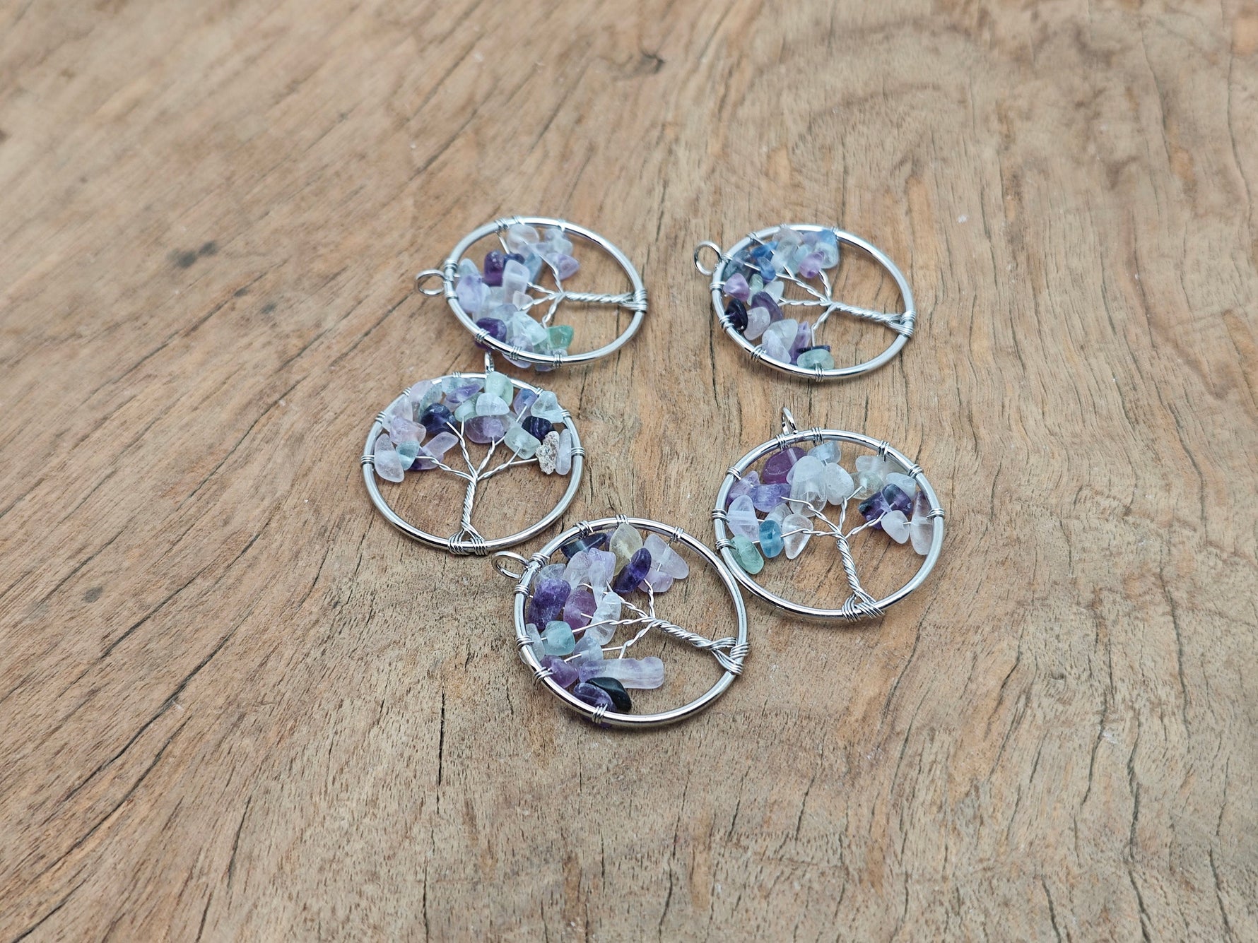 Fluorite Tree of Life gemstone pendant by GemstoneGO featuring vibrant green and purple fluorite crystals on a wire-wrapped pendant.