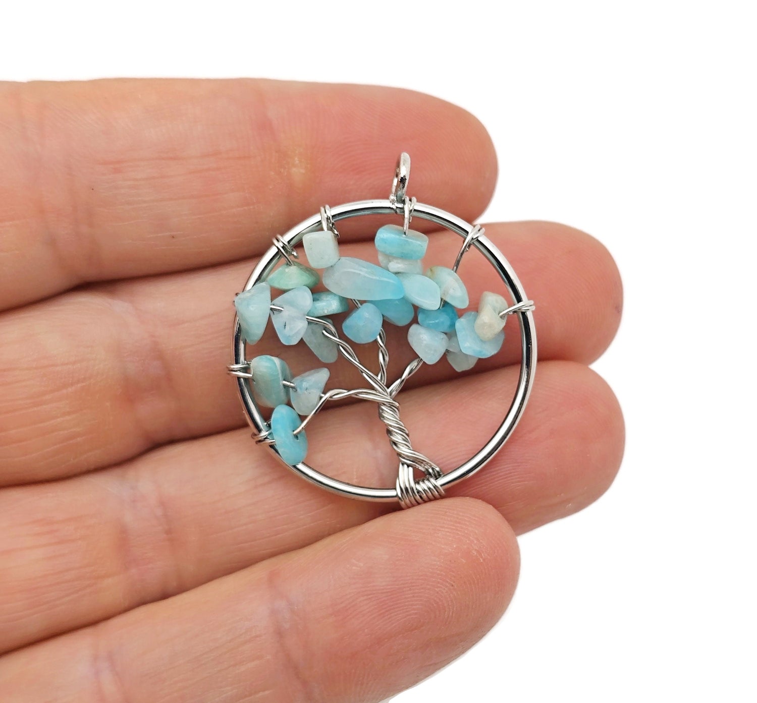 Amazonite Tree of Life gemstone pendant featuring intricate wire wrapping and vibrant blue-green stones on a neutral background.