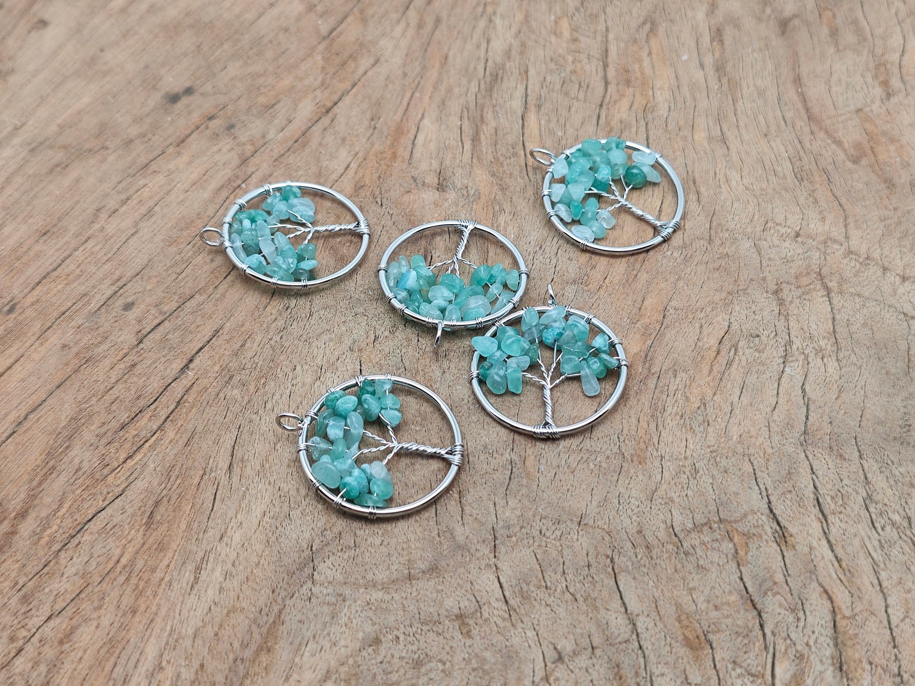 A gemstone Aventurine Tree of Life pendant featuring intricate wire wrapping and a vibrant green gemstone, handcrafted jewelry.