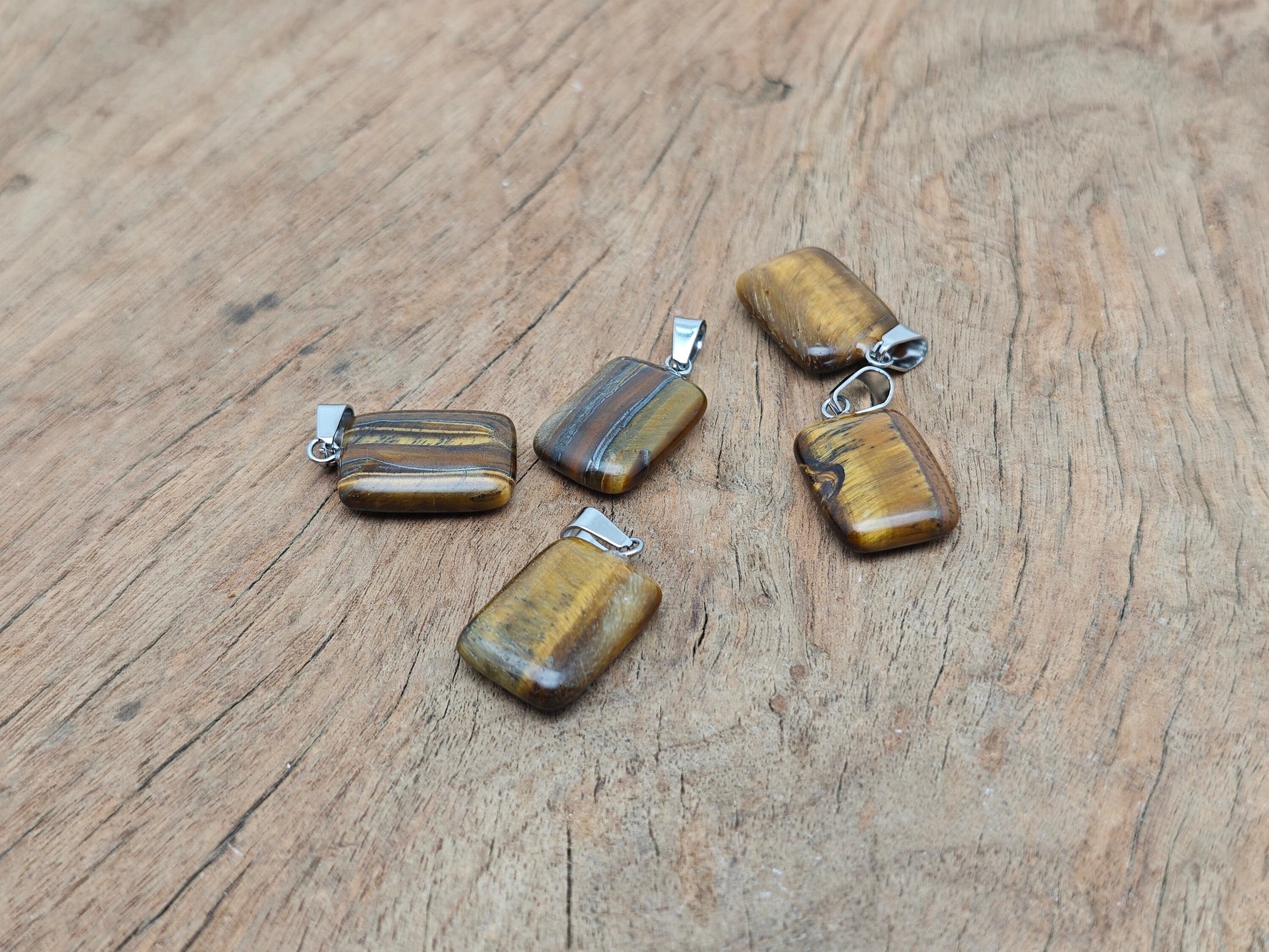 Tiger Eye rectangle-shaped crystal pendant from GemstoneGO, showcasing a polished gemstone with natural gold and brown tones.