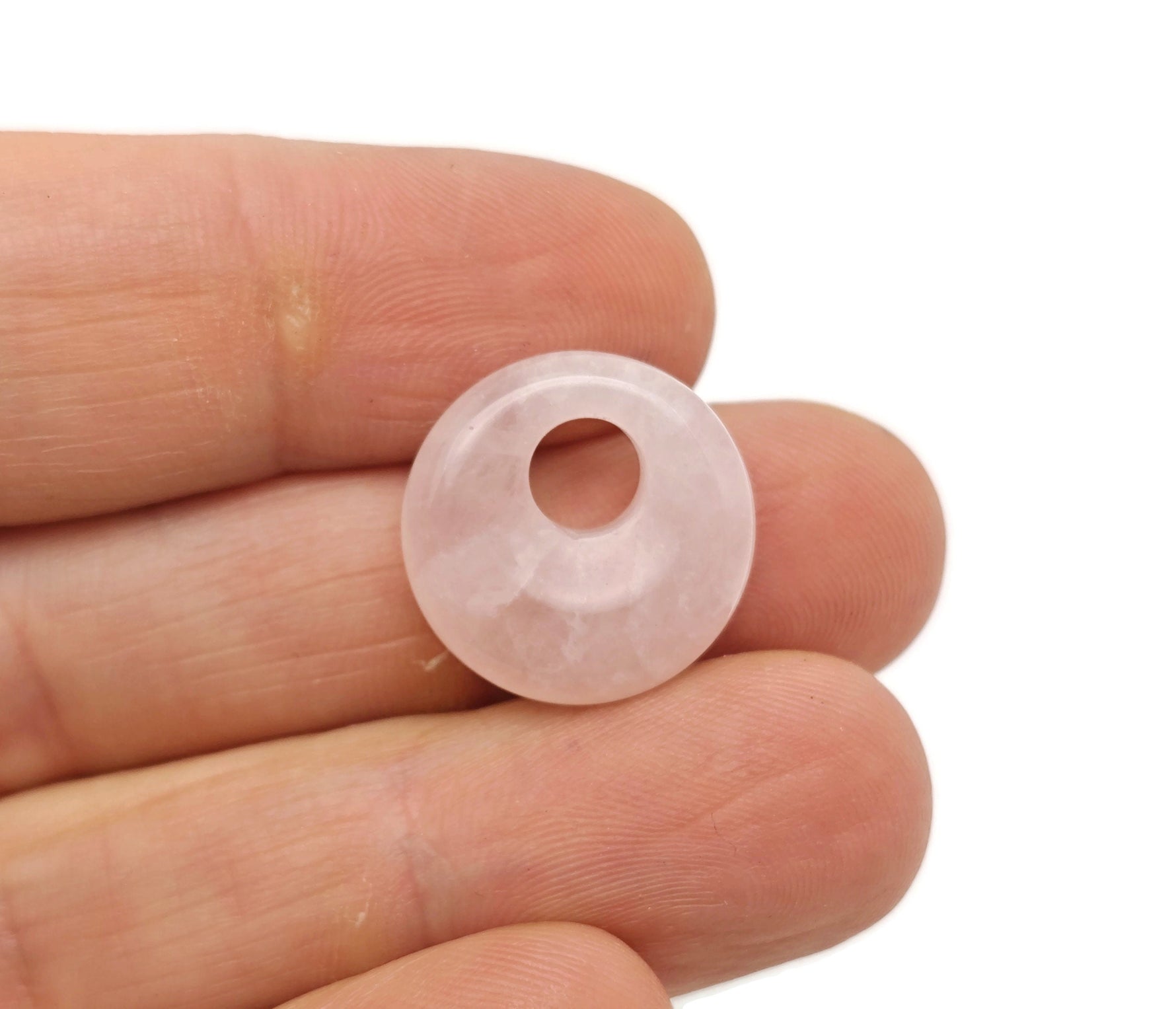 Pink rose quartz crystal donut pendant from GemstoneGO, 18mm Pi stone with polished smooth surface and natural gemstone appearance.