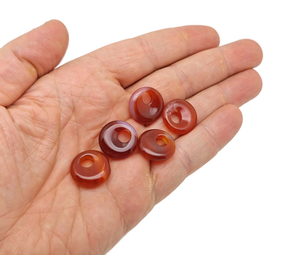 Carnelian crystal donut pendant from GemstoneGO, 18mm Pi Stone with vibrant orange color and smooth polished surface.
