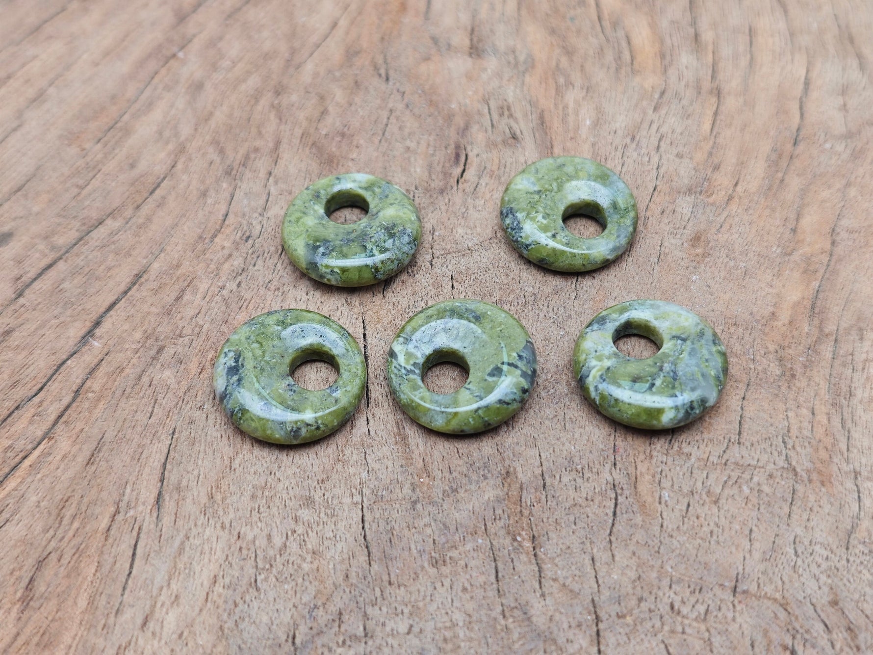 Unakite crystal donut pendant, 18mm Pi stone from GemstoneGO, featuring vibrant green and pink hues, polished and smooth surface.