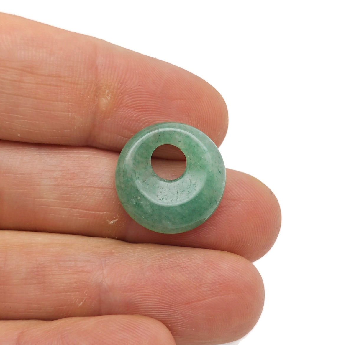 A close-up of an 18mm aventurine crystal donut pendant with green and brown hues, showcasing the Pi stone design from GemstoneGO.