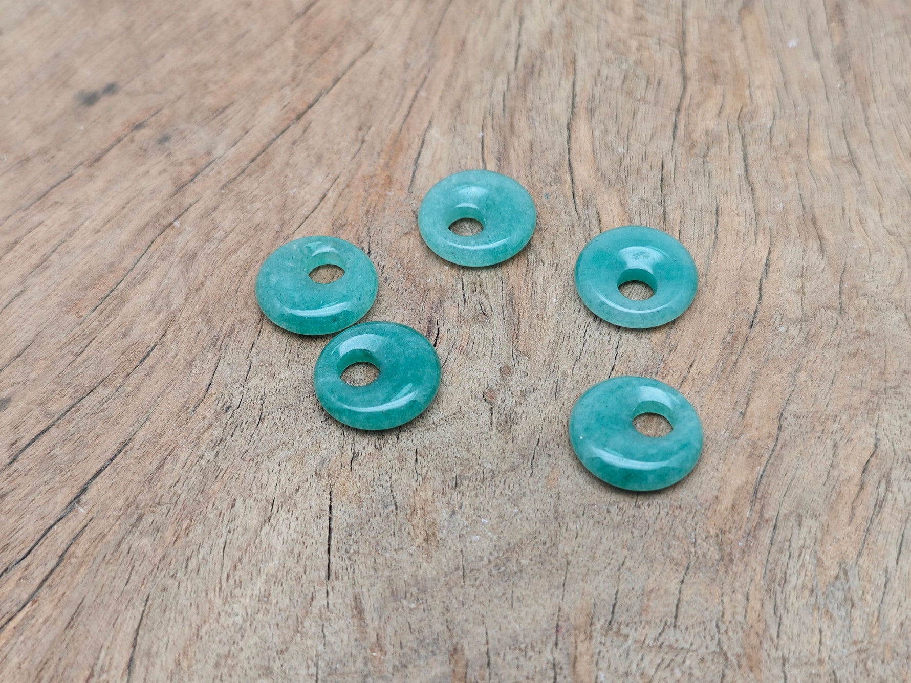 Aventurine crystal donut pendant from GemstoneGO, 18mm Pi Stone with smooth green gemstone surface on a white background.