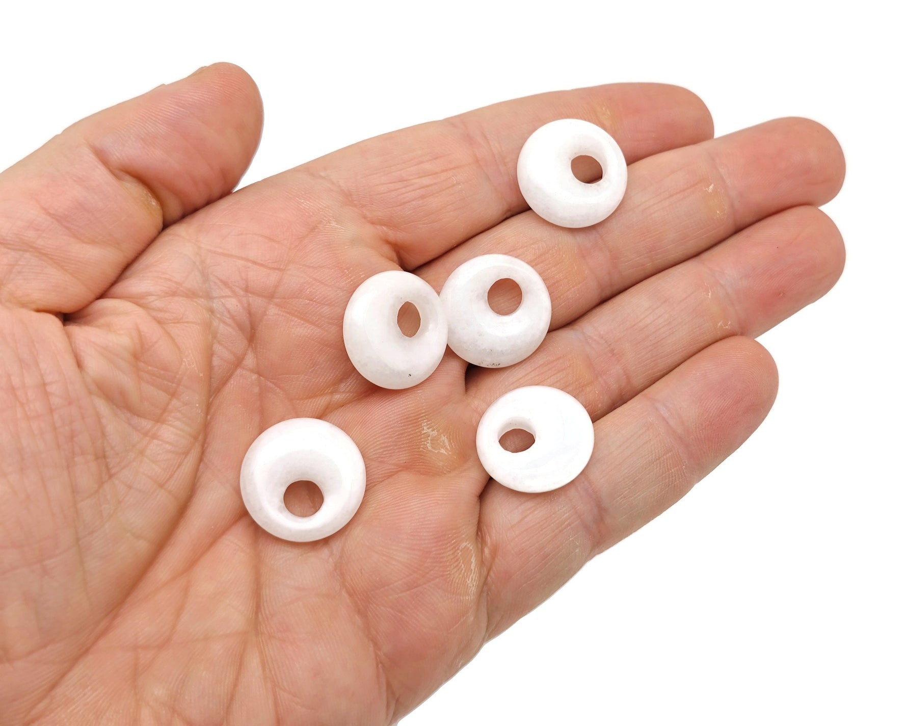 White jade crystal donut pendant with 18mm Pi stone from GemstoneGO, showcasing a smooth, polished gemstone with a hole in the center.