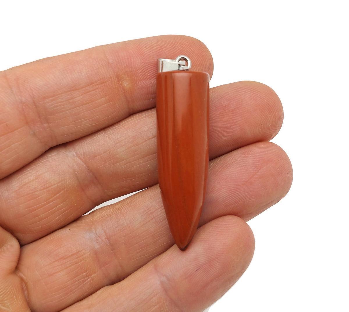 Polished red jasper bullet gemstone pendant carved in a bullet shape, featuring vibrant red and natural stone patterns.