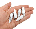 Polished Howlite bullet gemstone pendant with carved design, showcasing a smooth, white, and gray stone from GemstoneGO.