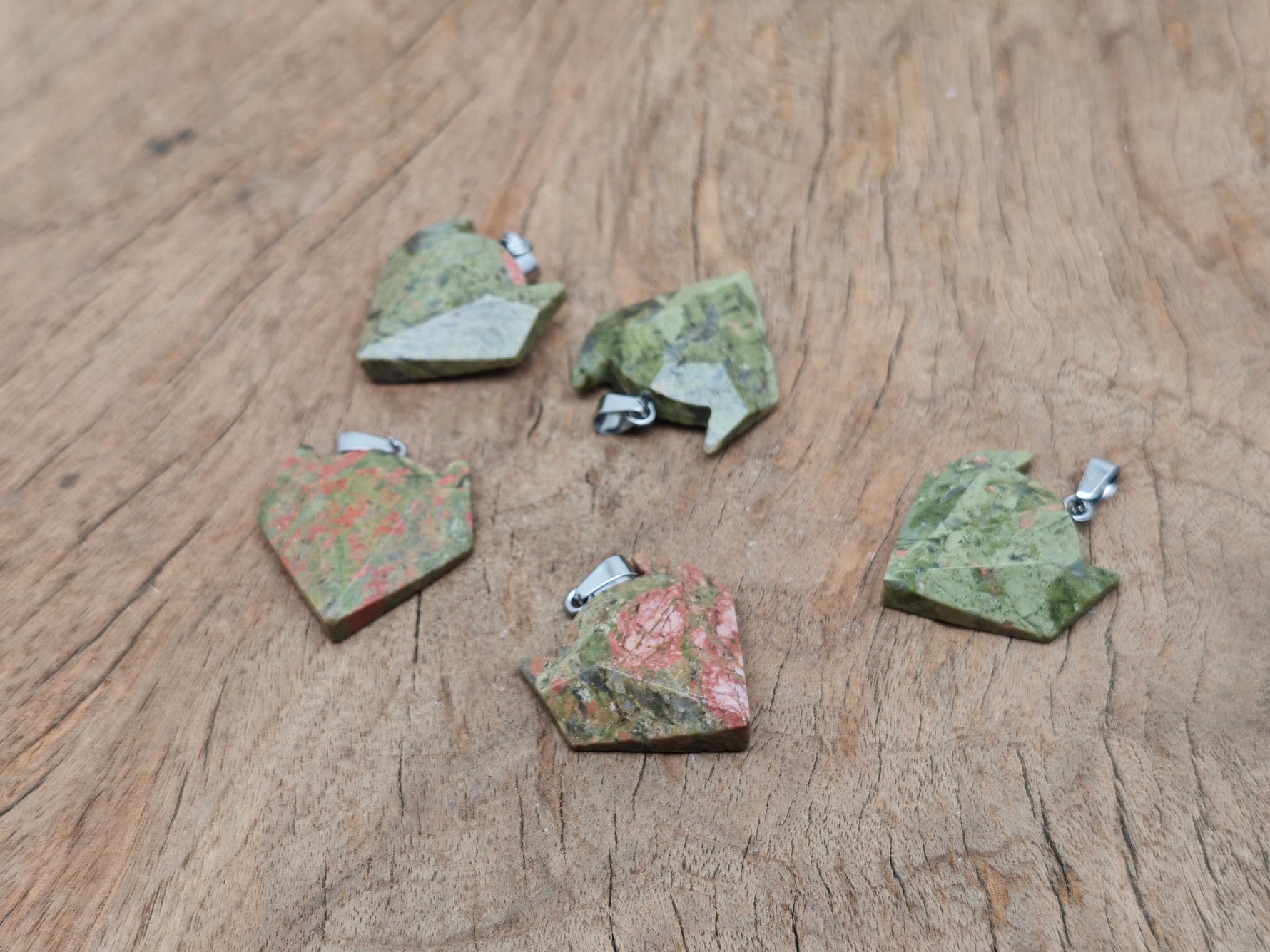 Unakite wolf head gemstone pendant from GemstoneGO, featuring a detailed carved crystal jewelry piece with vibrant green and pink hues.