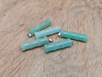 Aventurine bamboo-shaped crystal pendant from GemstoneGO with protective crystal design on a silver chain.