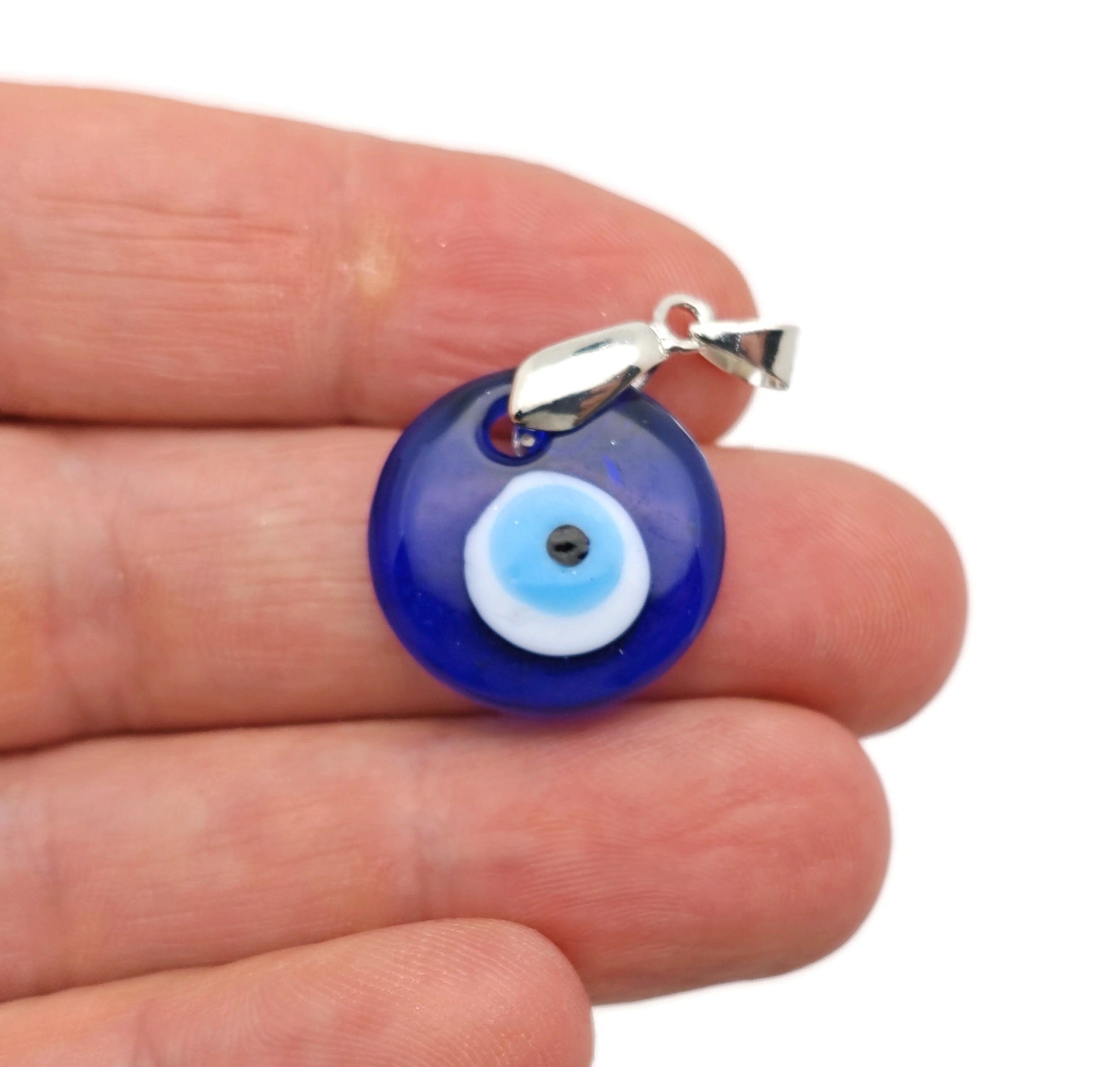 Glass evil eye pendant jewelry by GemstoneGO featuring a blue and white protective evil eye design on a clear glass pendant.