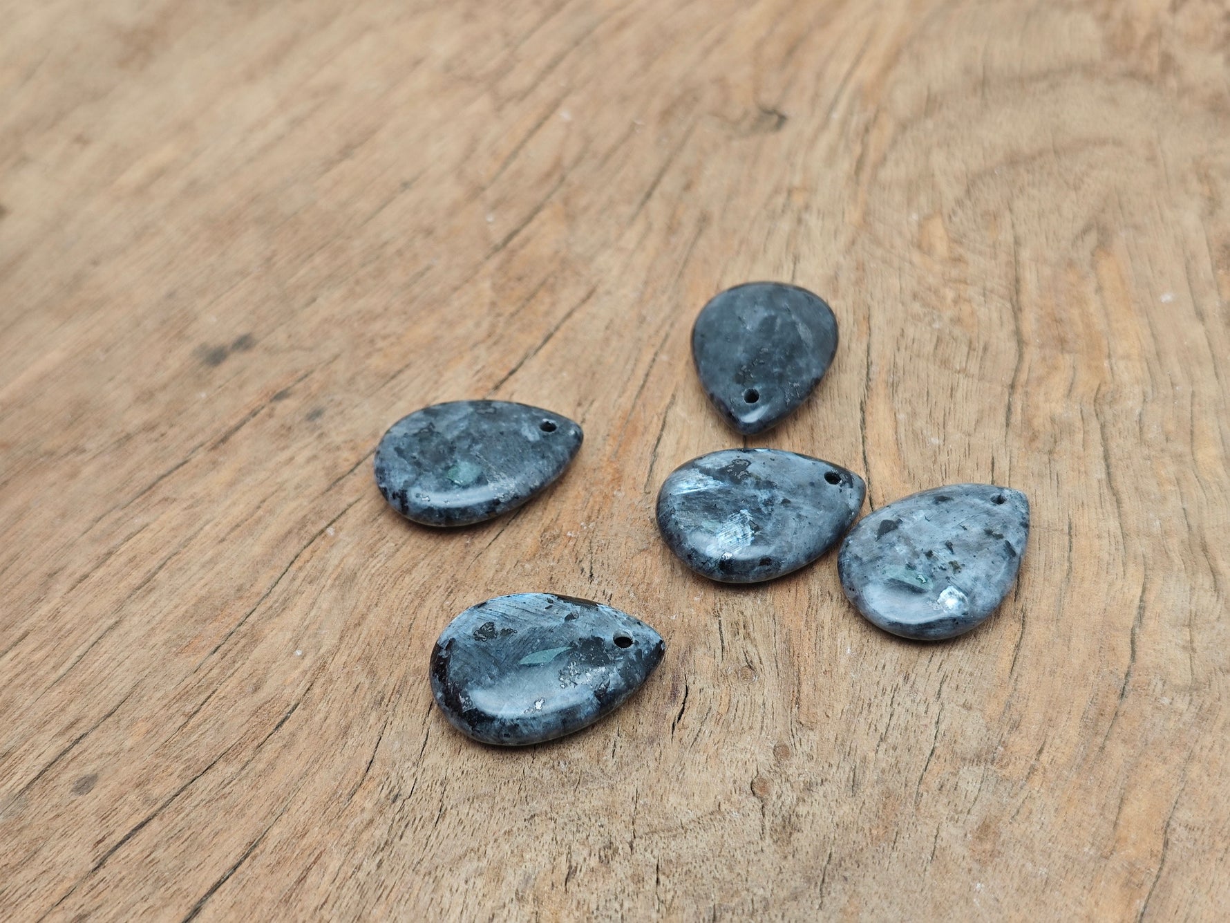 Larvikite dainty drop crystal pendant from GemstoneGO, showing a polished oval gemstone with a silver bail for DIY jewelry making.