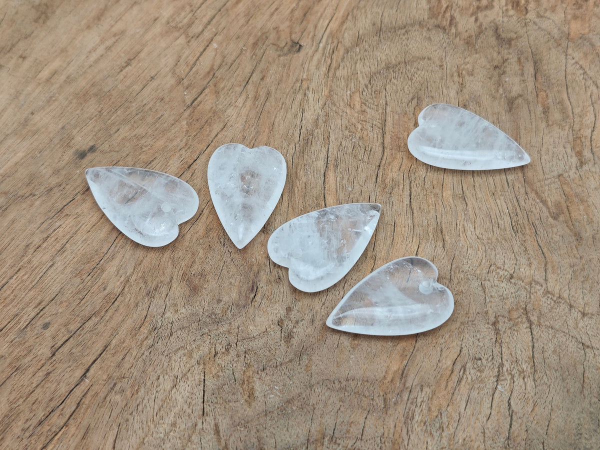 Clear quartz long heart-shaped love crystal pendant with a polished gemstone and silver bail, perfect for jewelry and healing.