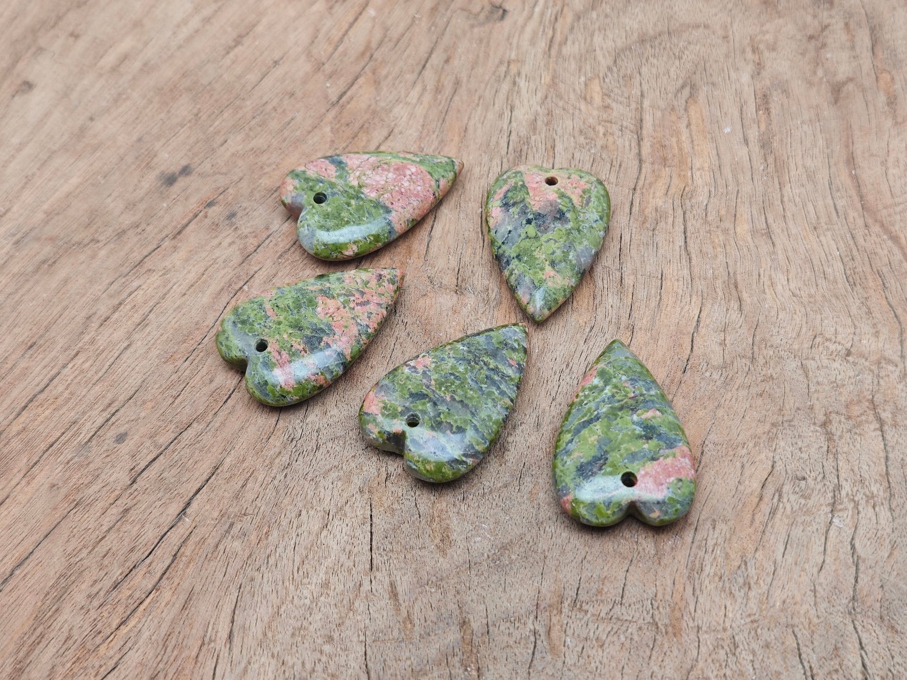 Heart-shaped Unakite love crystal pendant with a polished gemstone and silver bail, perfect for healing and meaningful jewelry.