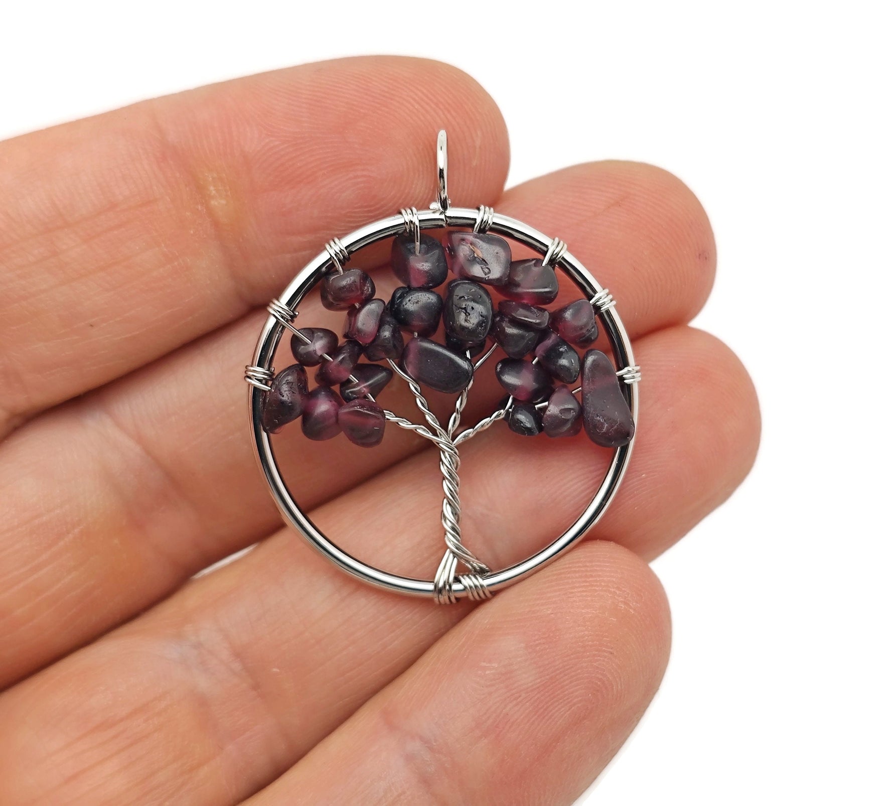Garnet Tree of Life gemstone pendant with intricate wire wrapping, showcasing vibrant red crystals on a silver chain.