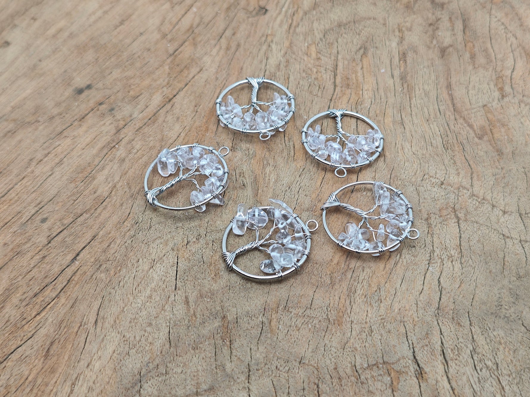 Clear quartz Tree of Life gemstone pendant with intricate wire wrapping, showcasing natural crystal and detailed craftsmanship.