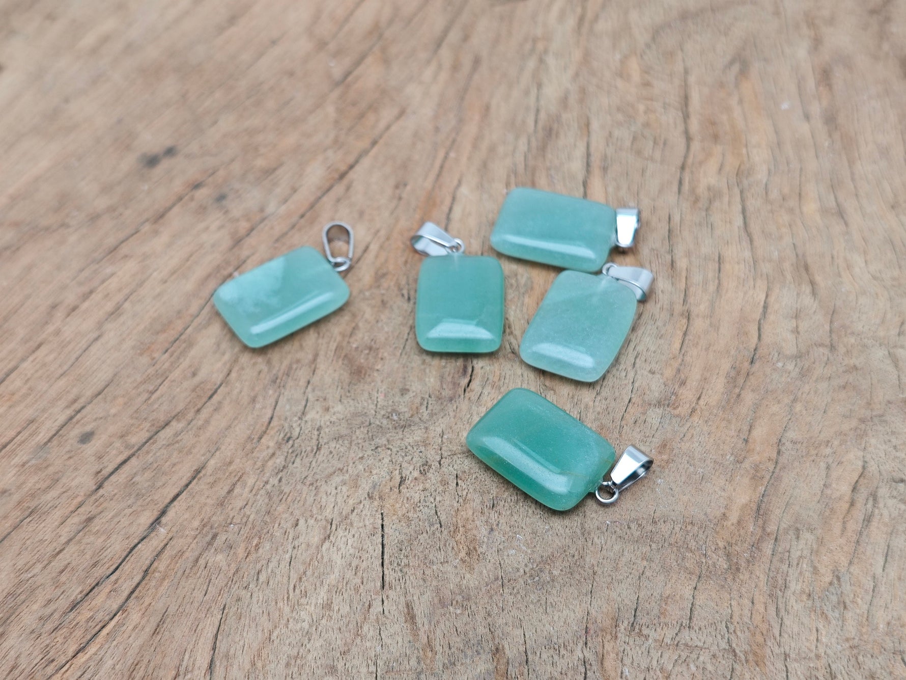 A rectangular aventurine gemstone pendant from GemstoneGO, featuring a polished green crystal with natural inclusions.