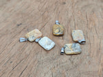 Rectangle-shaped Crazy Lace Agate crystal pendant from GemstoneGO, showcasing vibrant banded patterns on a silver setting.