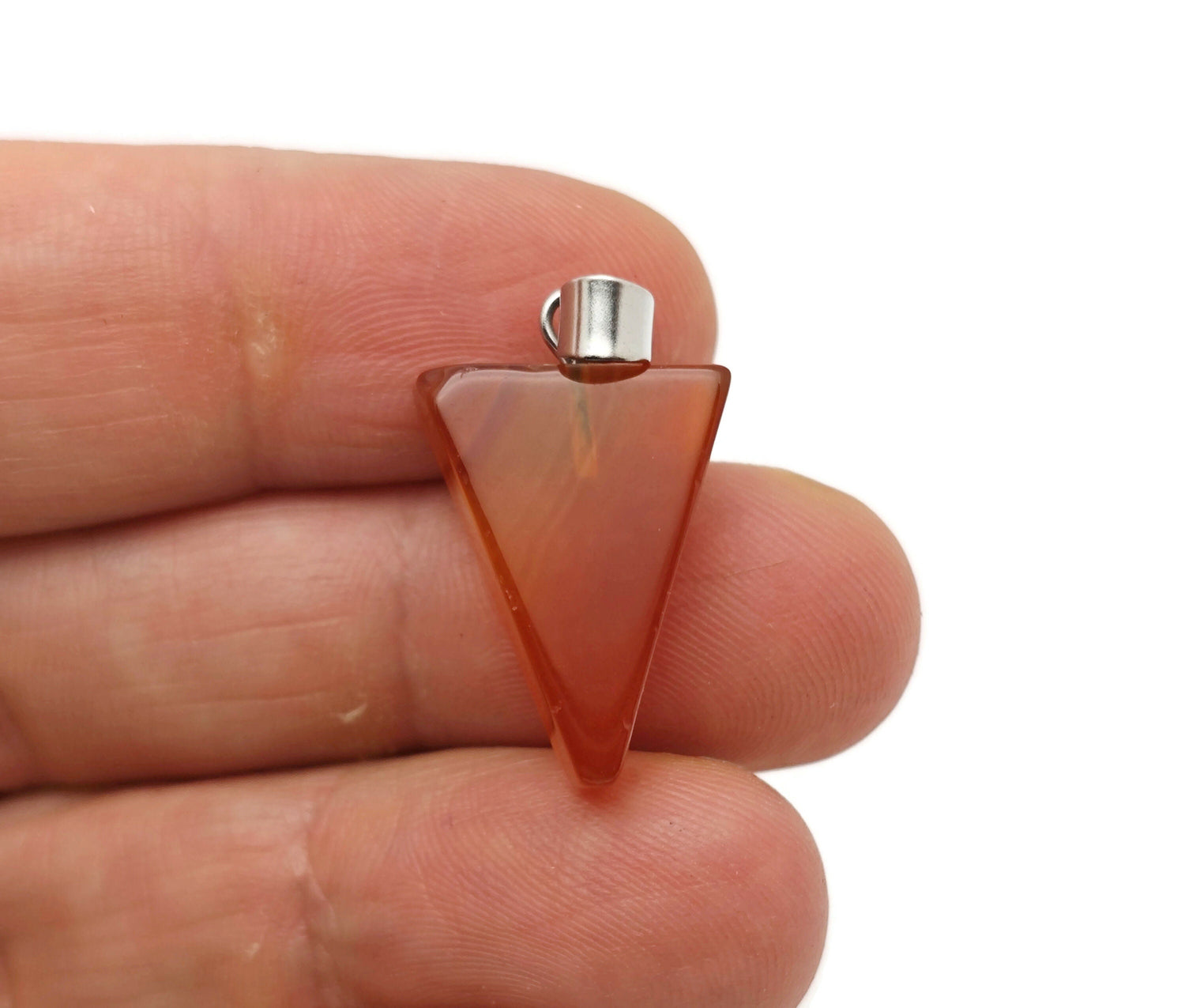 Carnelian triangle-shaped crystal pendant from GemstoneGO, showcasing its vibrant orange gemstone with polished surface.