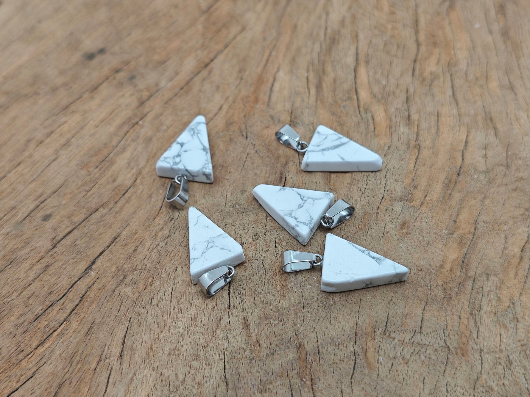Bulk wholesale Howlite triangle-shaped crystal pendant from GemstoneGO, showcasing smooth white stone with subtle gray veining.