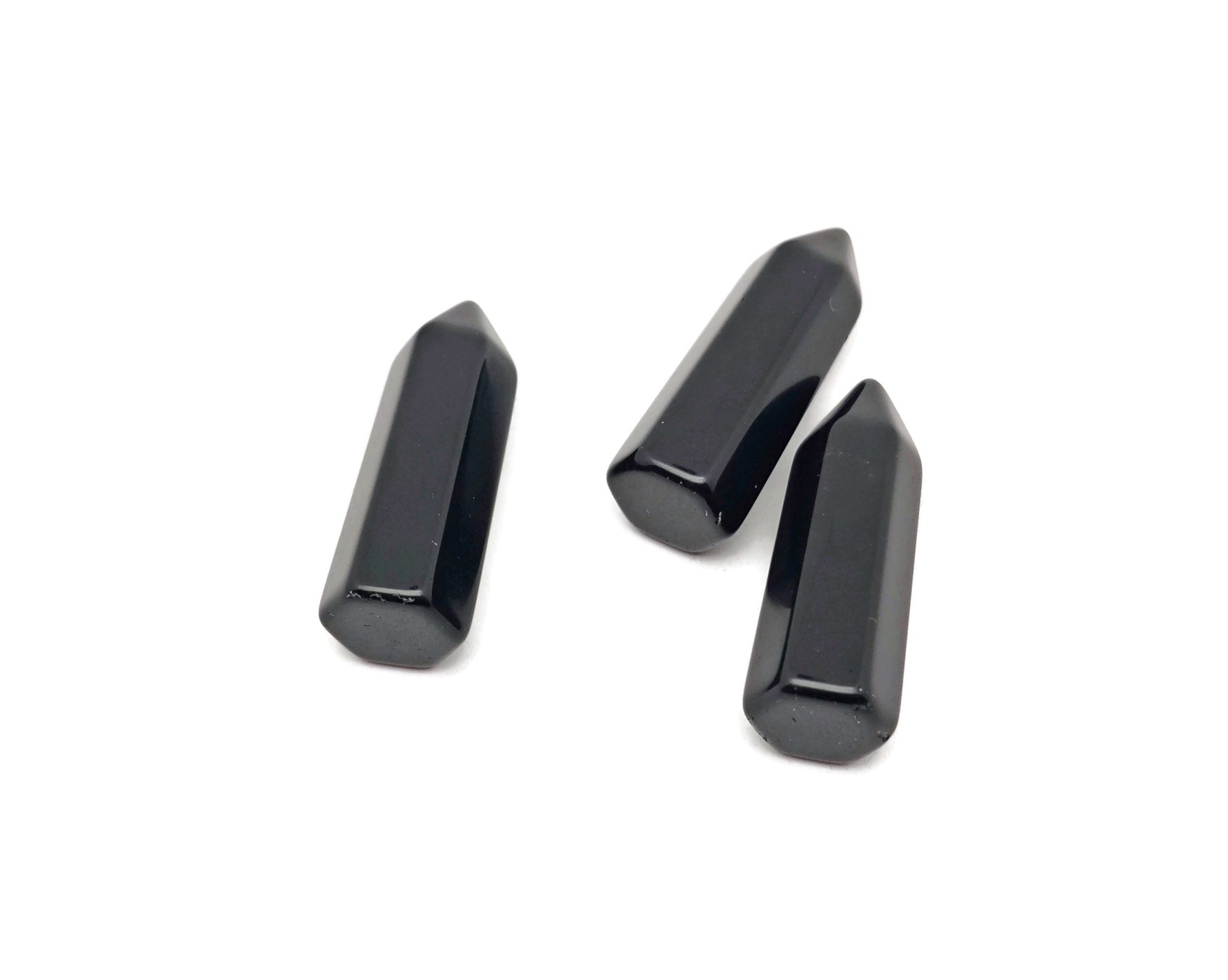Polished 40mm black Obsidian Obelisk Tower crystal from GemstoneGO, showcasing its smooth, glossy surface and pointed shape.