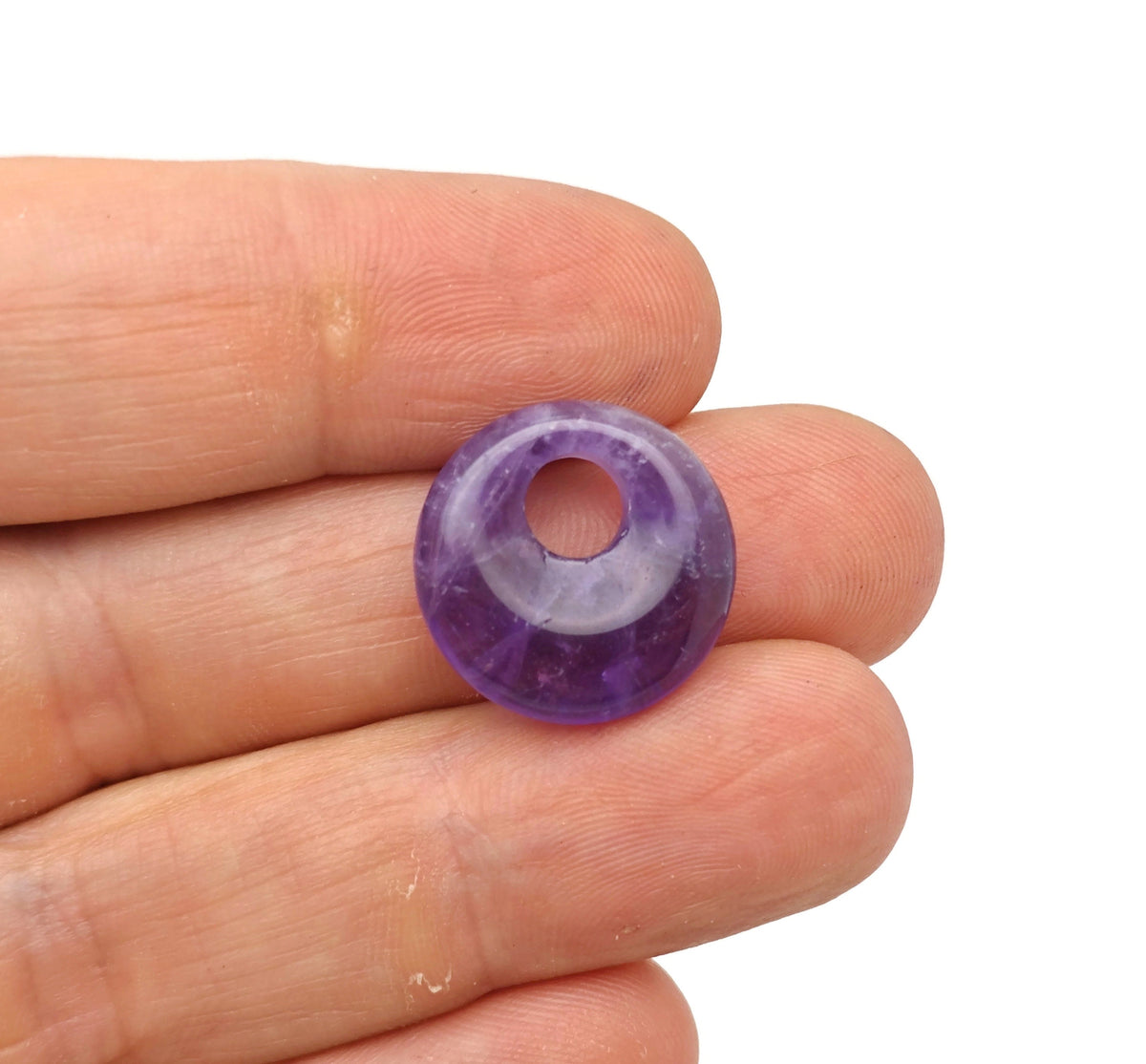 Amethyst crystal donut pendant from GemstoneGO, 18mm Pi stone with purple gemstone and polished surface.