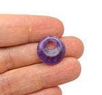 Amethyst crystal donut pendant from GemstoneGO, 18mm Pi stone with purple gemstone and polished surface.