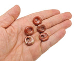 Red Jasper crystal donut pendant from GemstoneGO, 18mm Pi Stone, showcasing a polished red jasper stone with natural patterns.