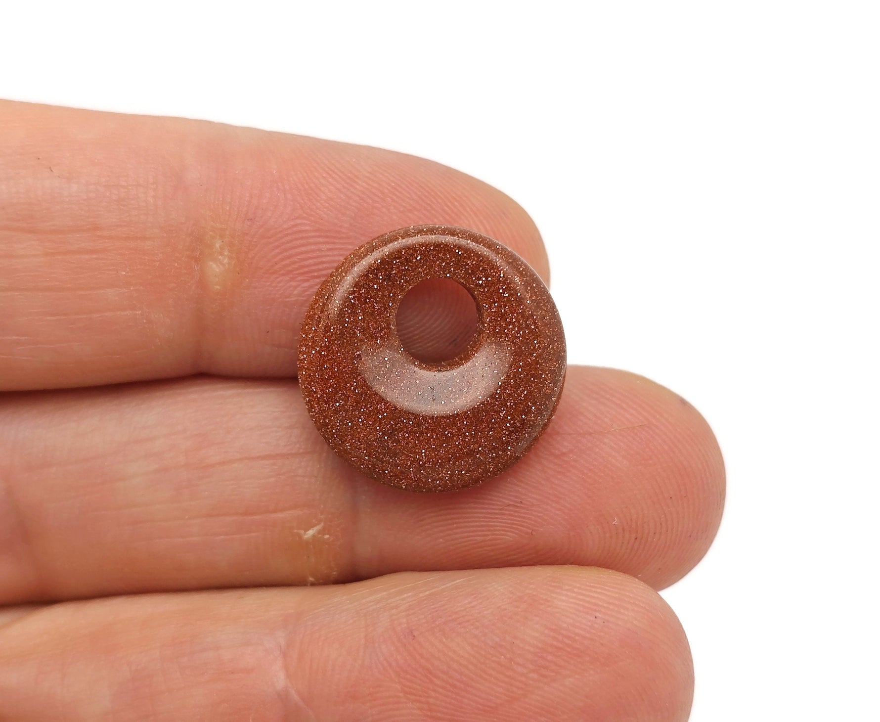 Goldstone crystal donut pendant with a polished 18mm Pi Stone design from GemstoneGO, showcasing a shimmering, rounded gemstone.
