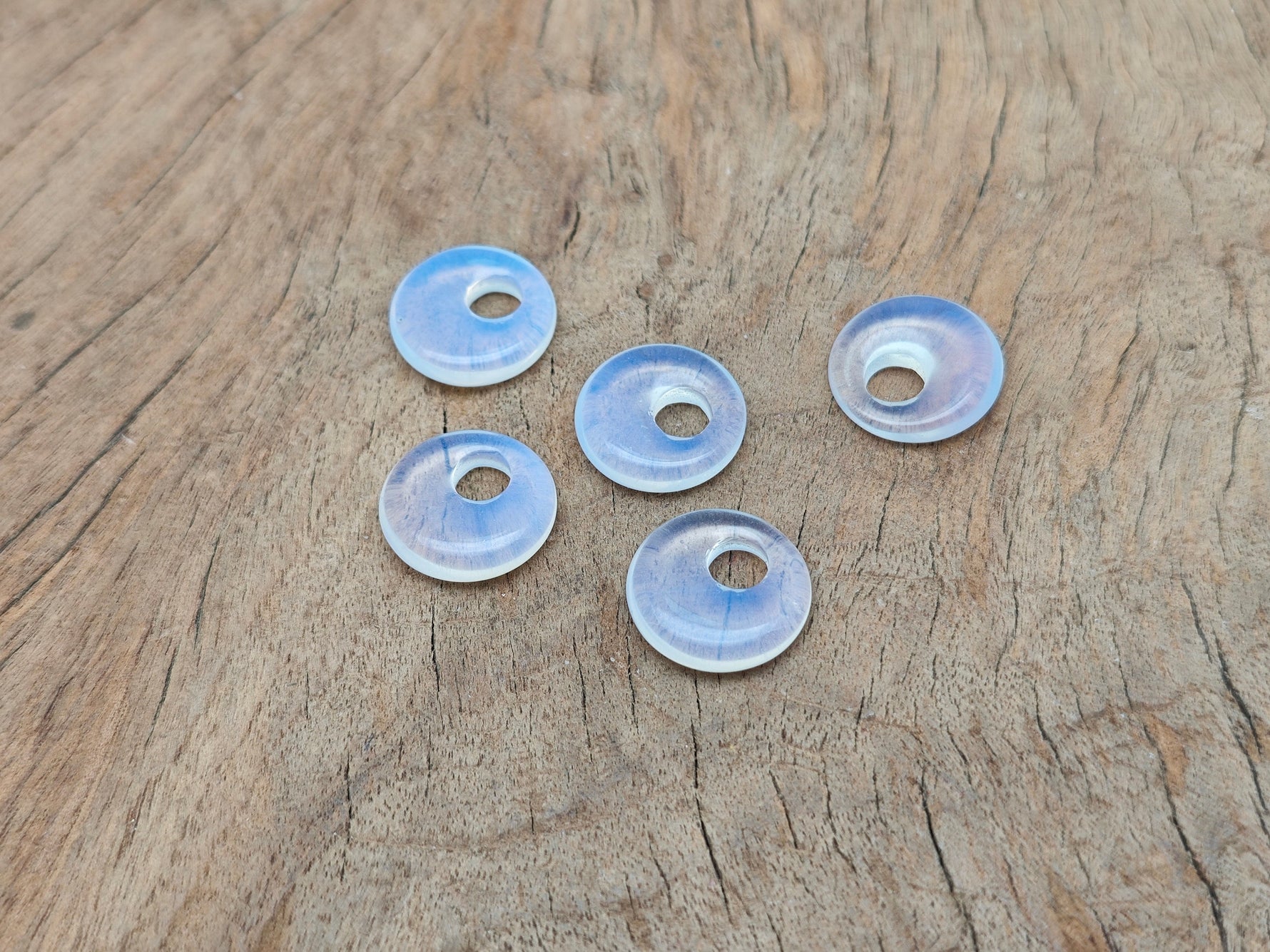 Opalite crystal donut pendant, 18mm Pi stone from GemstoneGO, showcasing a smooth, oval-shaped gemstone with a glowing, milky appearance.
