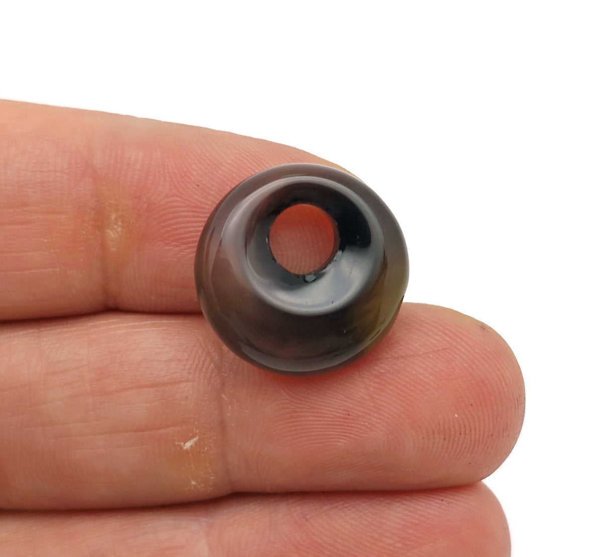 Black agate crystal donut pendant, 18mm Pi stone by GemstoneGO, showcasing a smooth, polished black agate gemstone with a donut shape.