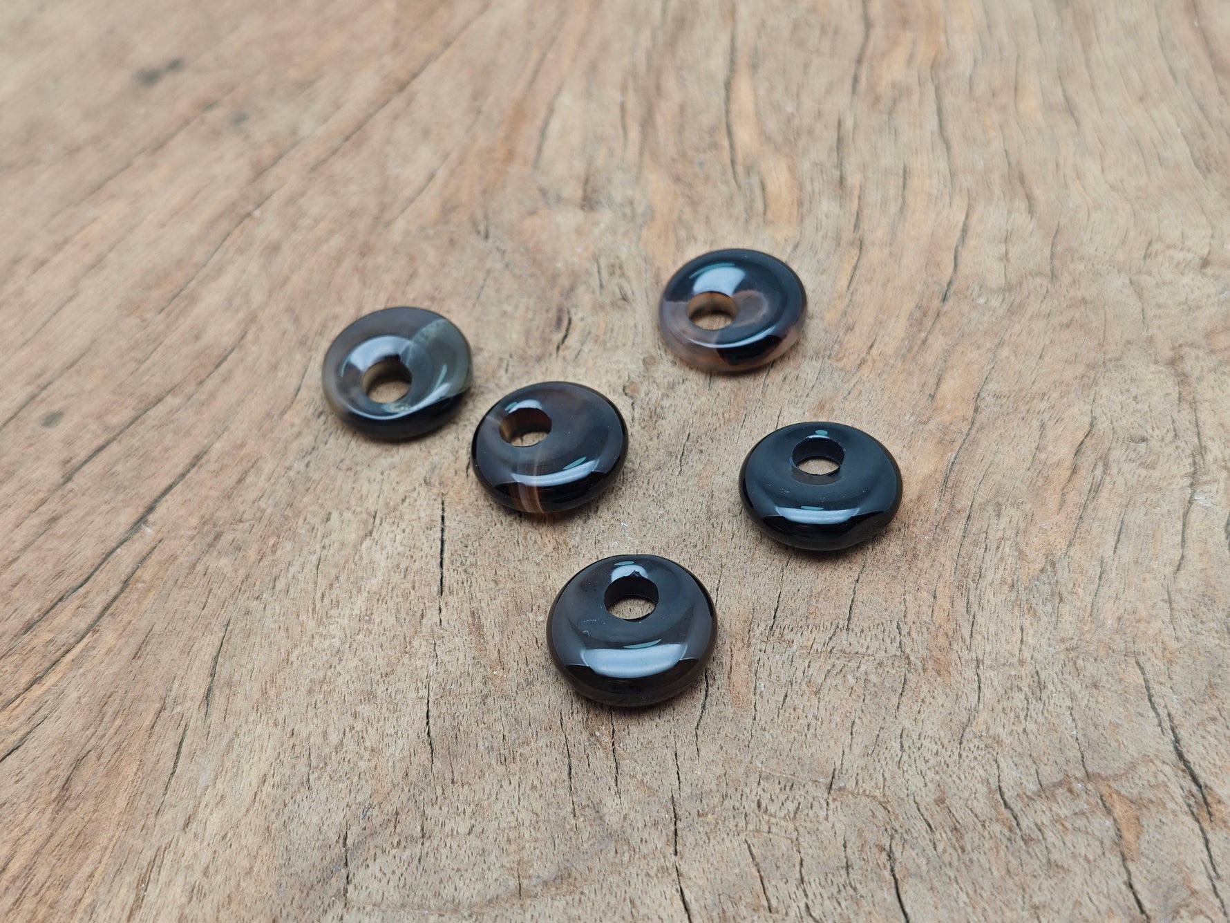 Black Agate crystal donut pendant from GemstoneGO, 18mm Pi Stone with polished black agate and intricate details.