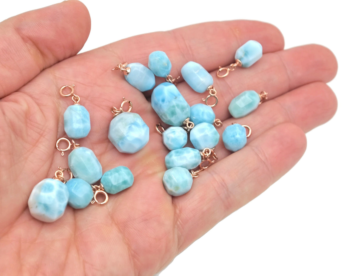 Larimar crystal pendant with gold setting, showcasing a vibrant blue gemstone in a elegant jewelry design.