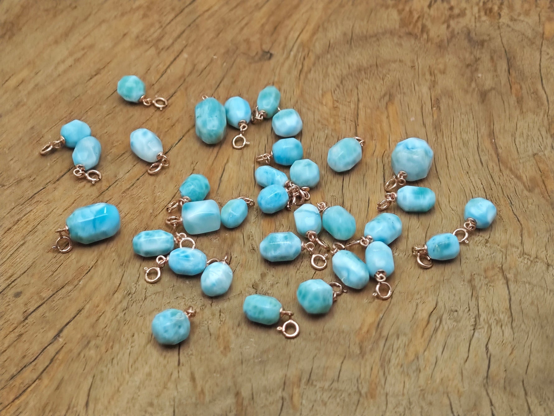 Larimar crystal pendant with gold setting from GemstoneGO, showcasing a smooth, oval-shaped blue gemstone on a delicate chain.